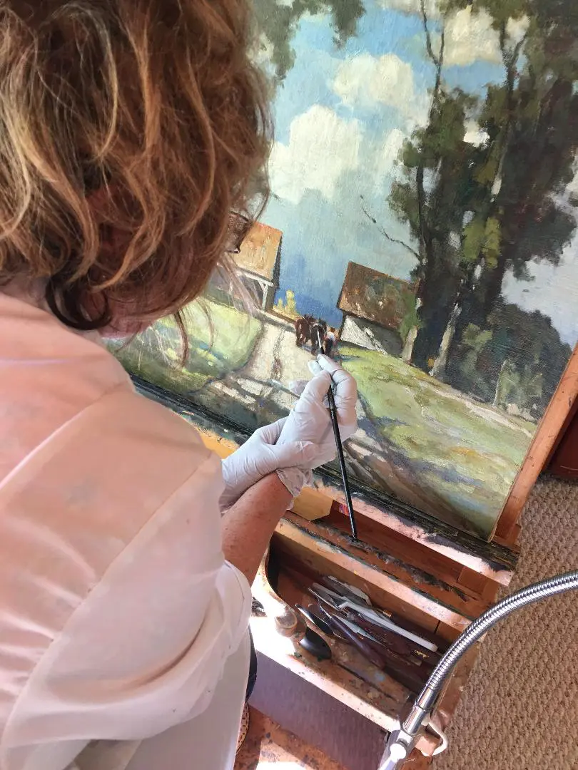 A woman painting an image on canvas.