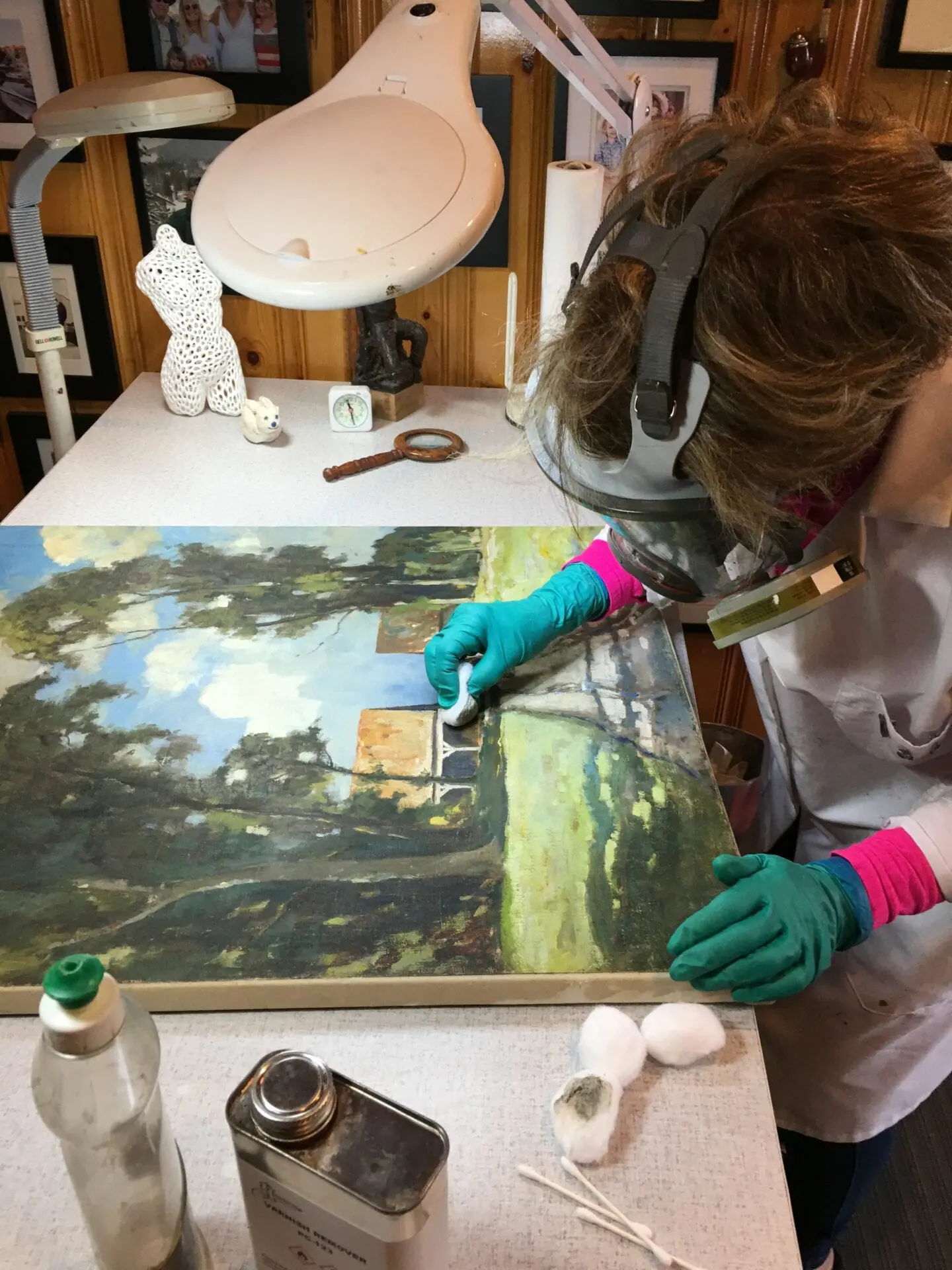 A person in gloves painting a picture on top of a table.